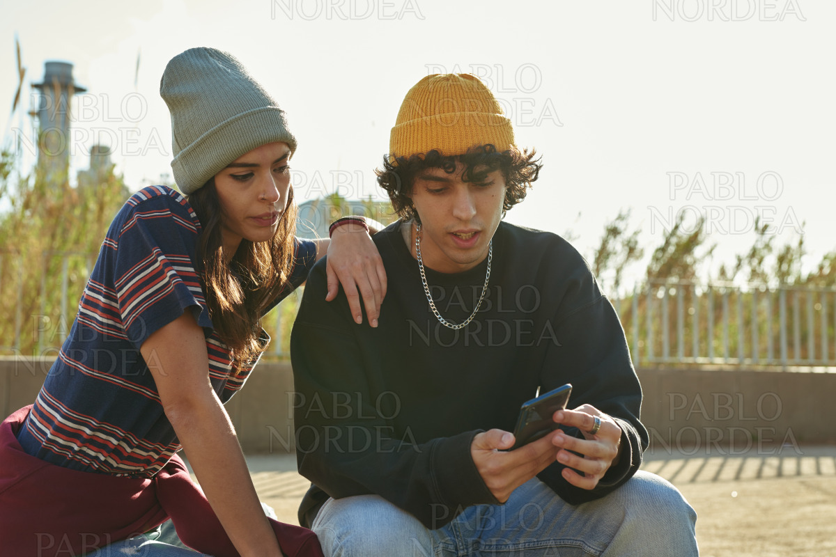Handsome guy showing girl something on his phone stock photo