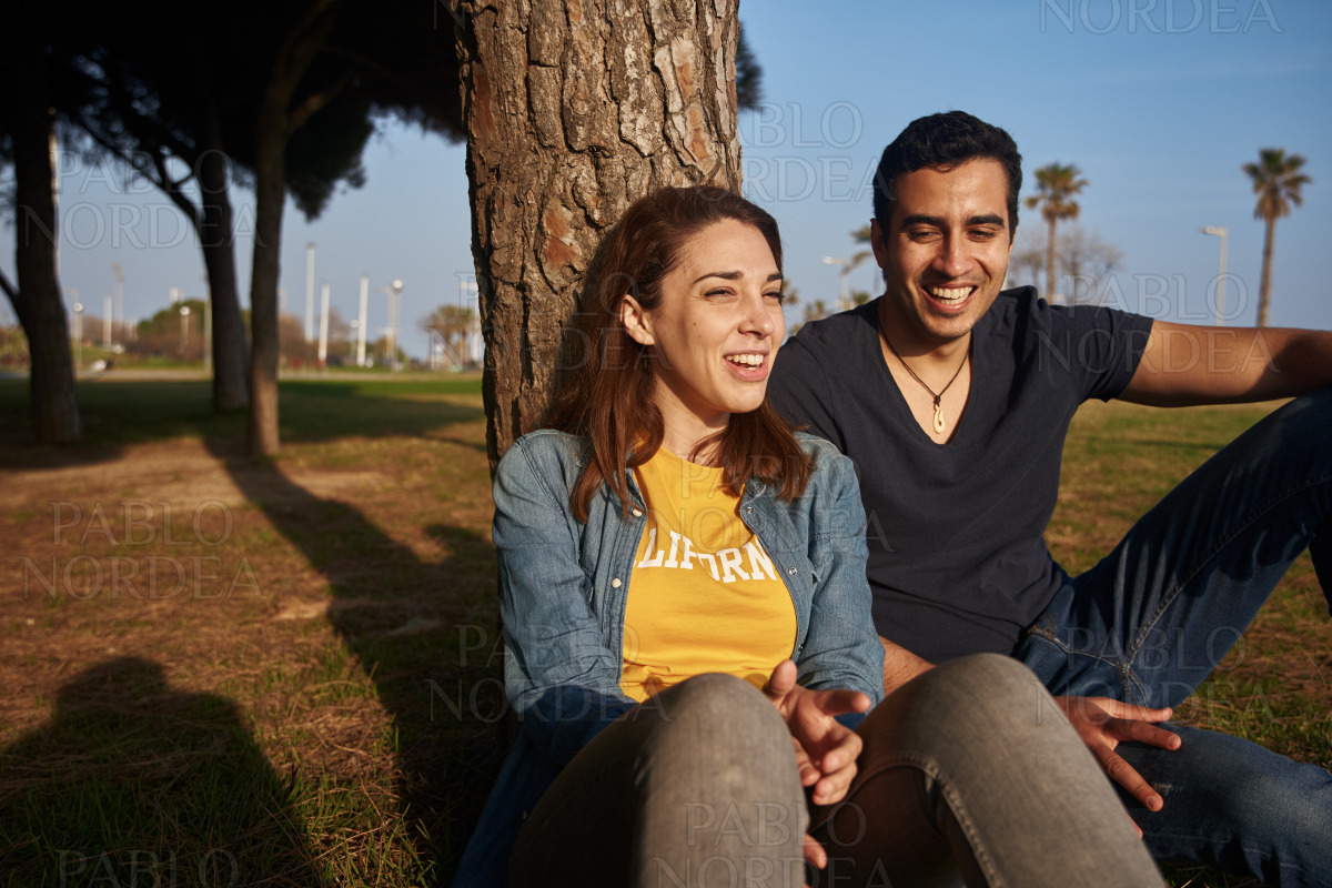 Man and woman laughing together in the park stock photo