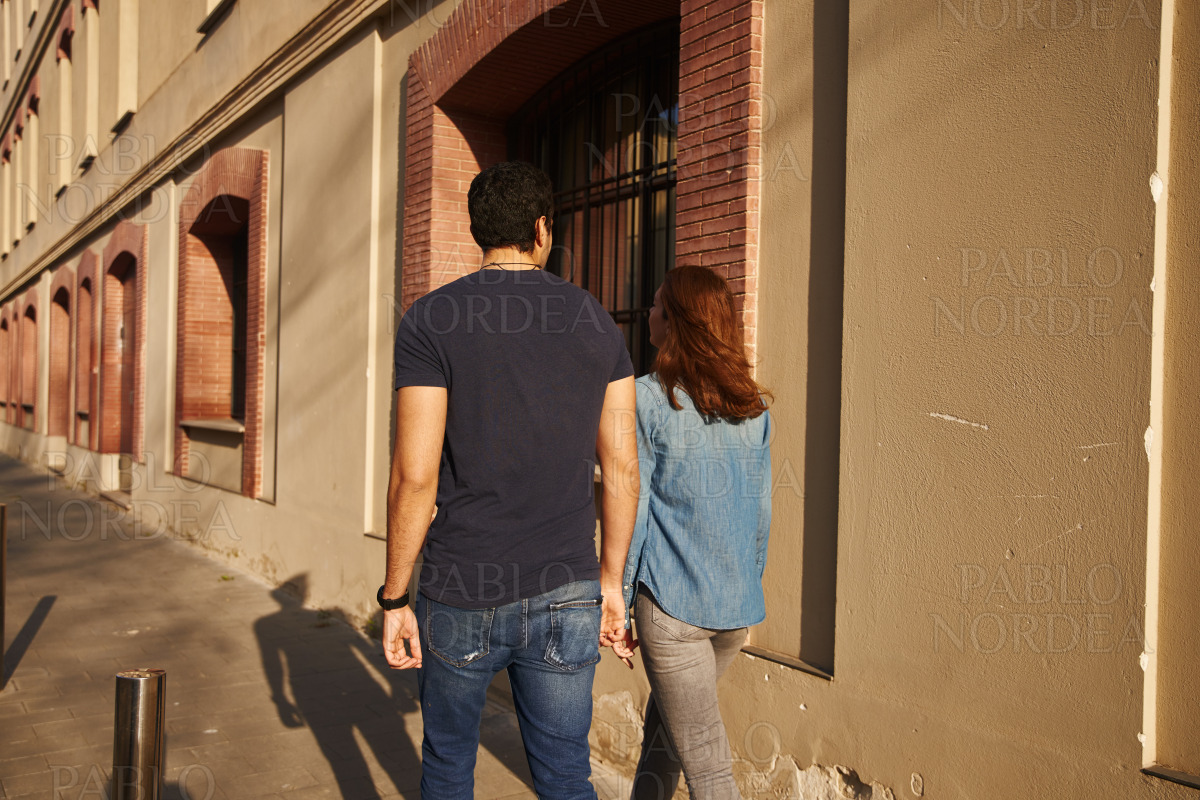 Rear view of a couple walking in the street stock photo