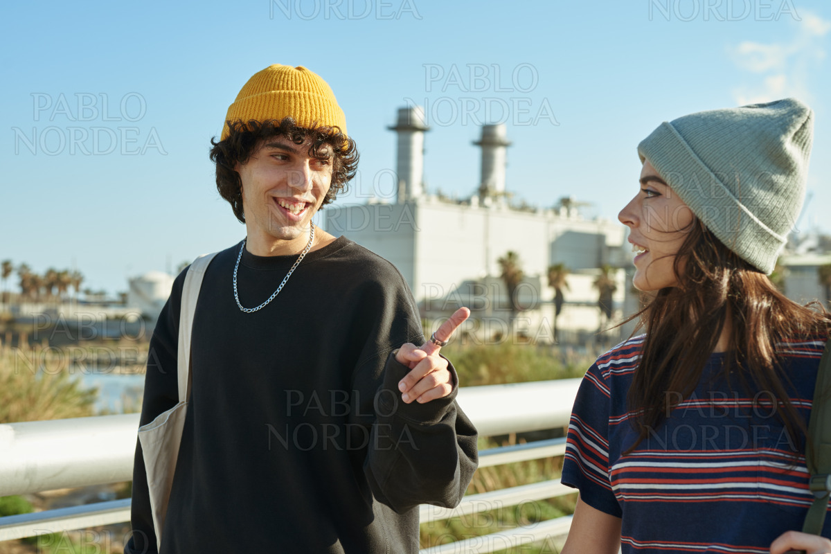 Smiling young couple chatting while walking stock photo