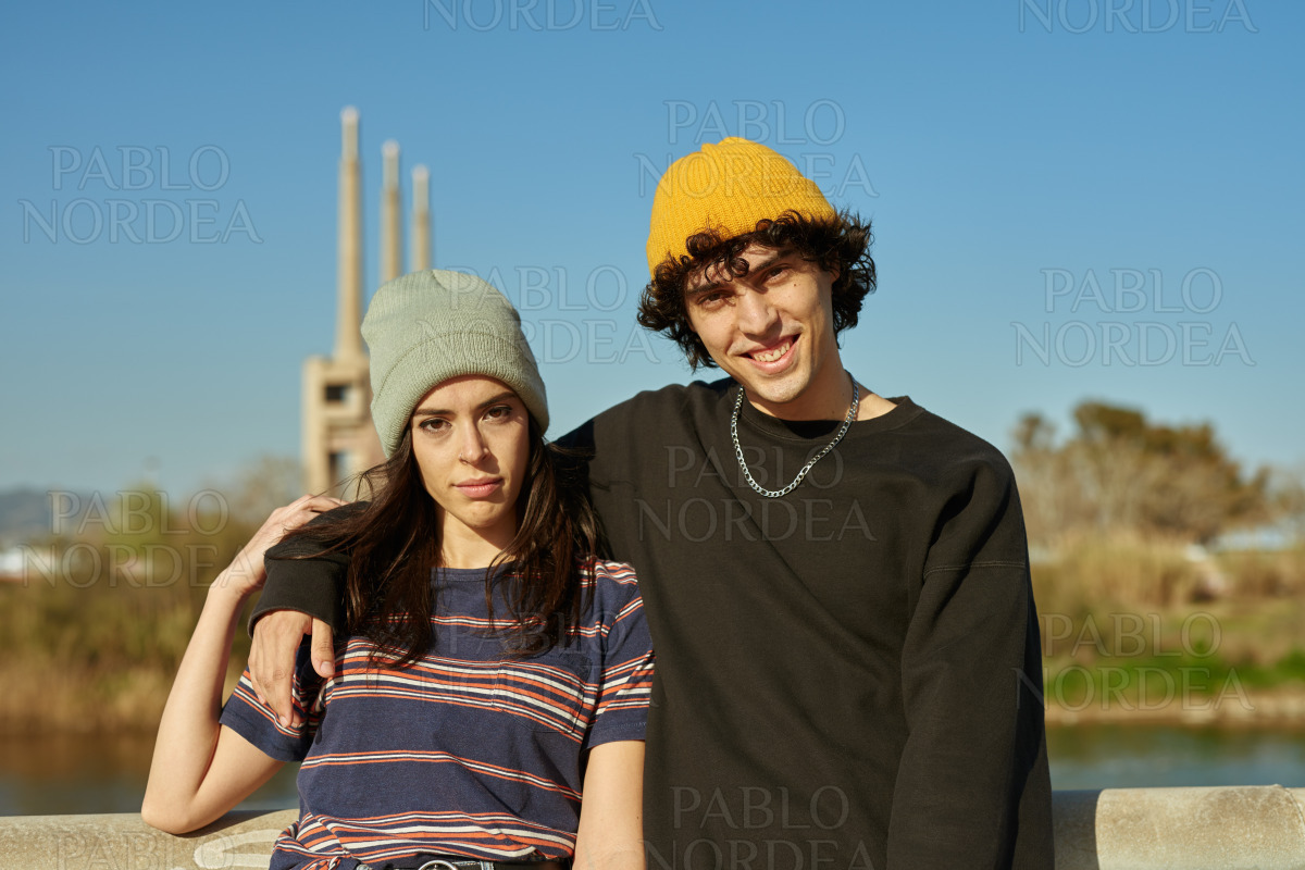 Smiling young guy with his arm around his girl stock photo