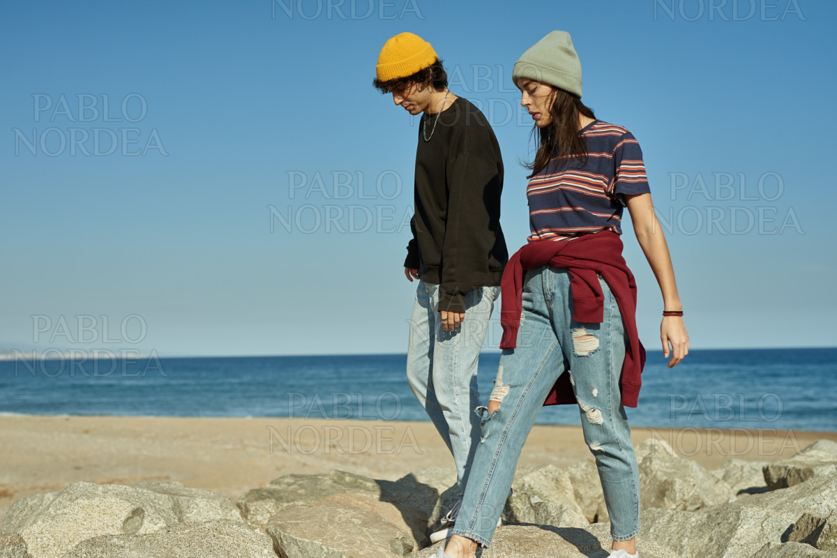 Two blissful young people walking along the beach stock photo
