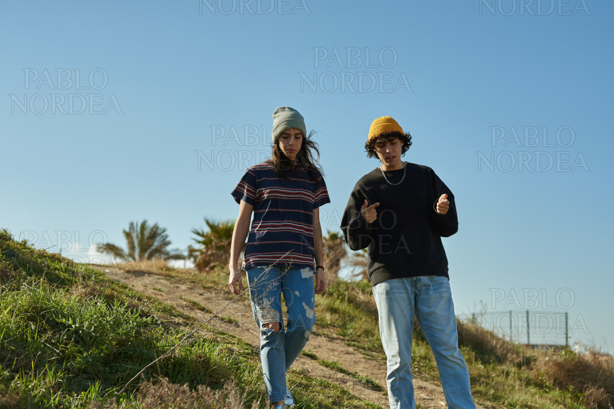 Two captivated young people walking down a hill stock photo