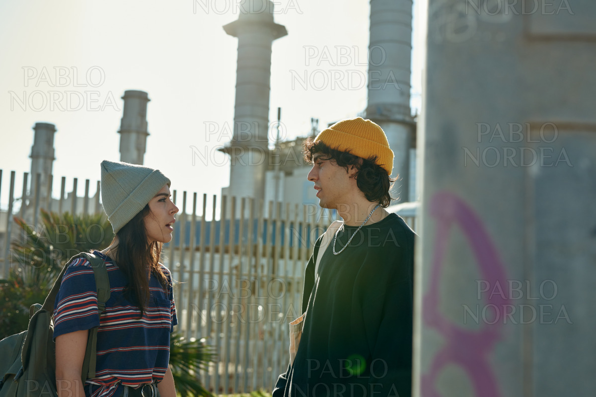 Two chatty young people standing next to a pole stock photo
