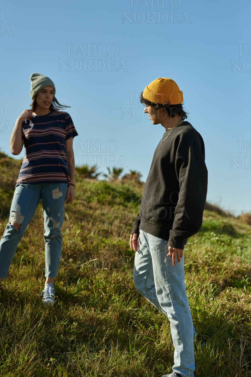 Two engaged young people standing on a hill stock photo