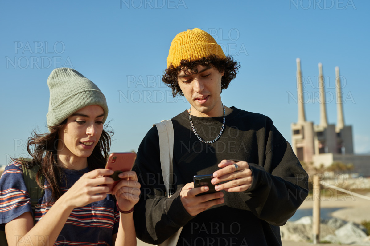 Two engulfed young people busy on their phones stock photo