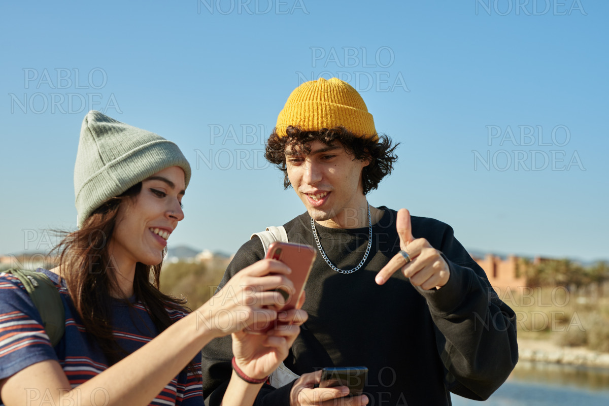 Two gripped people engaging with their phones stock photo