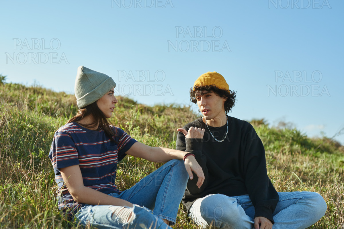 Two involved young people talking on a hill stock photo