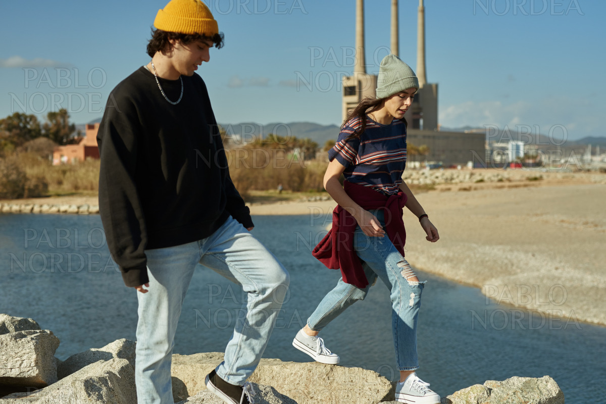 Two unconfined young people walking along the sea stock photo