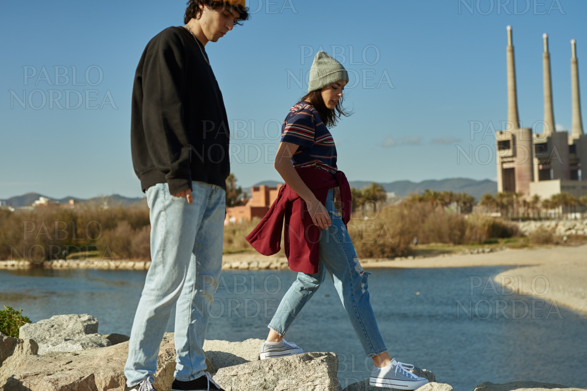 Two untethered young people walking on rocks stock photo