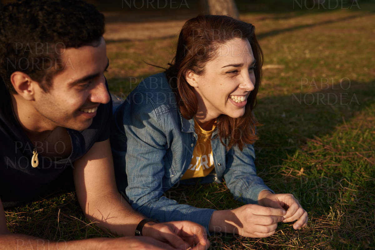 Young couple laughing and smiling in the park stock photo