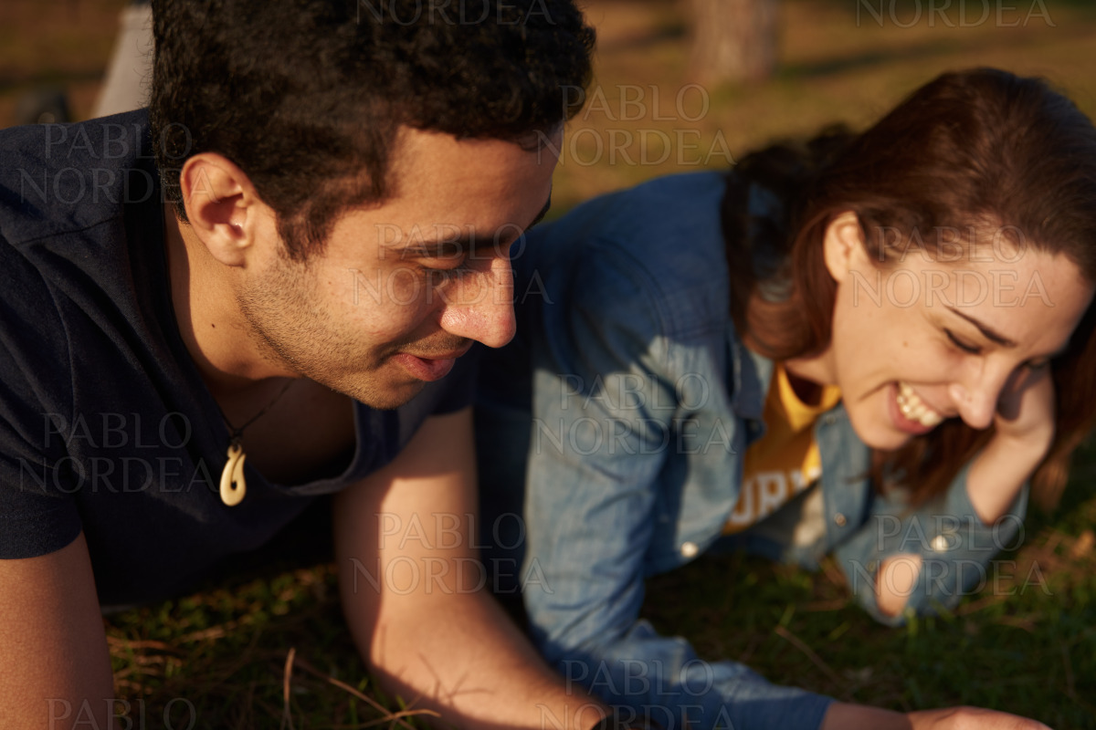 Young couple laughing together in the park stock photo