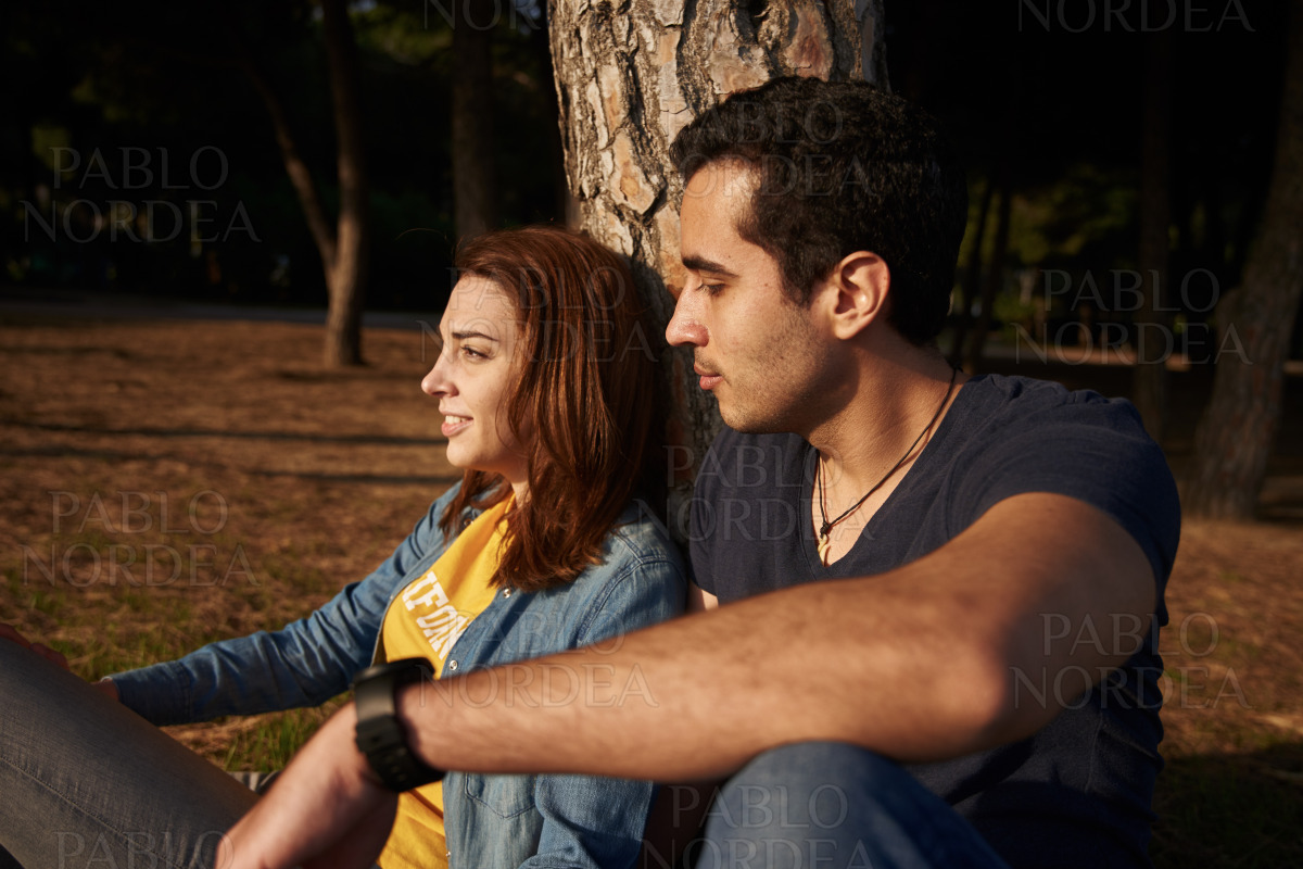 Young couple seated in the park stock photo