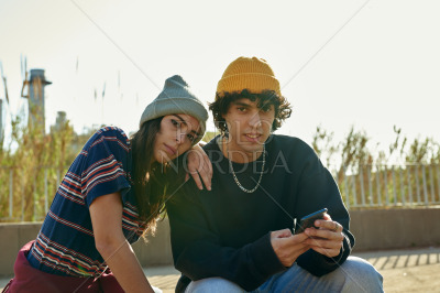 Attractive couple looking at you outdoors