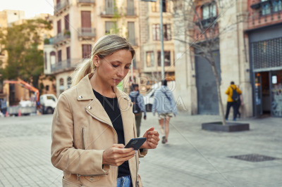 Attractive woman using mobile phone in the city