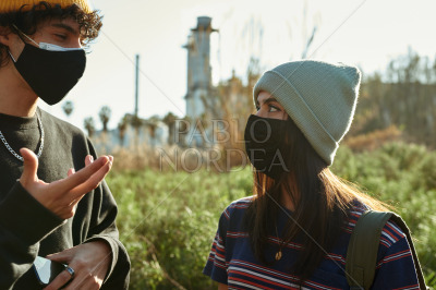 Couple in masks having a chat outdoors
