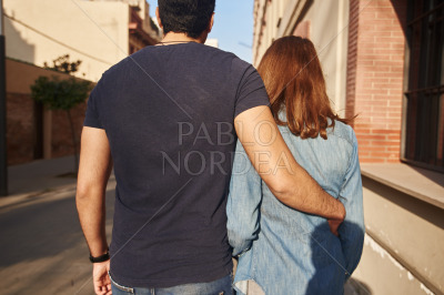 Couple walking arm in arm along a street