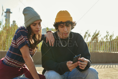 Handsome guy showing girl something on his phone