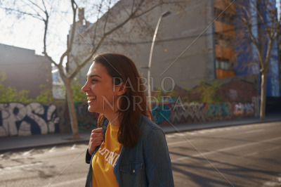 Smiling young woman walking down the street