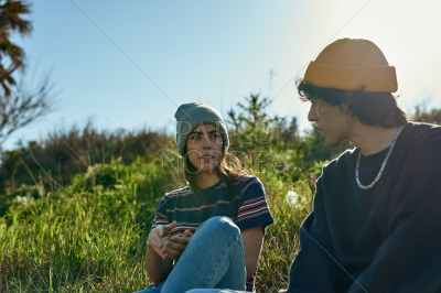 Two intrigued young people sitting on a hill