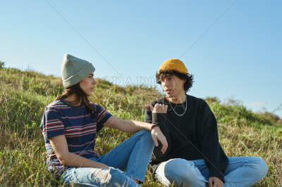 Two involved young people talking on a hill