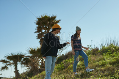 Two lively young people standing on a hill