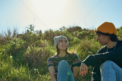 Two mesmerised young people sitting on a hill