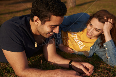 Woman leans up on her elbow and talks to man