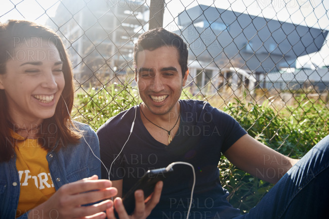 Couple laughing as they look at their phone
