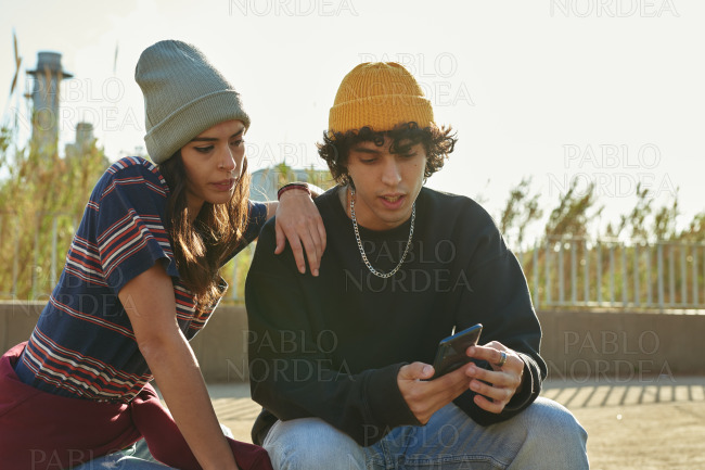 Handsome guy showing girl something on his phone
