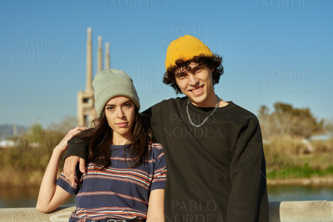 Smiling young guy with his arm around his girl