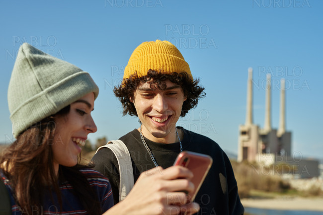 Two cheery young people standing outside smiling