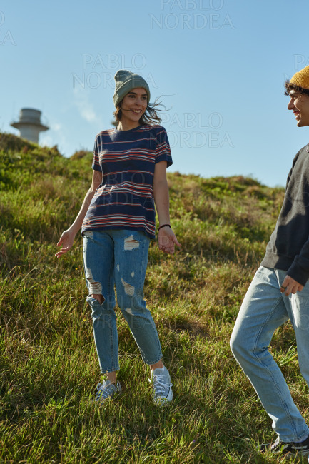 Two jovial young people talking on a steep hill