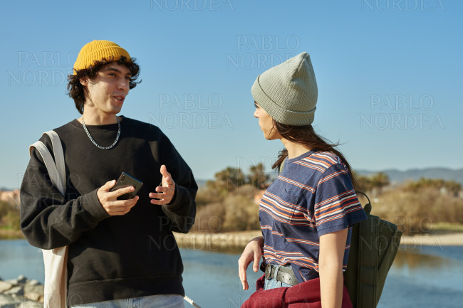 Two laid back young people having a chat outside stock photo