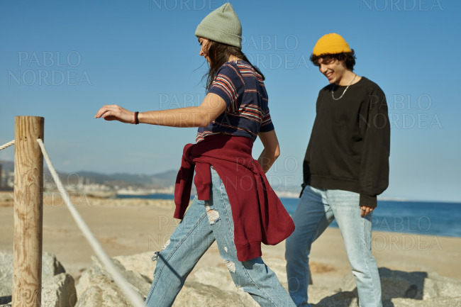 Two spirited young people climbing on rocks