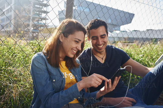 Young couple looking at a cell phone and laughing
