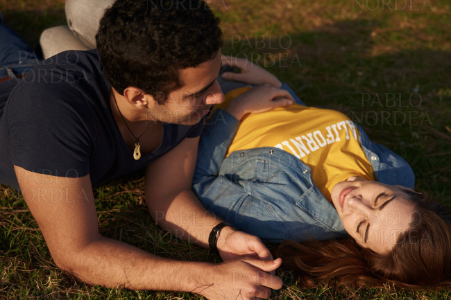 Young couple lying on the grass in the park