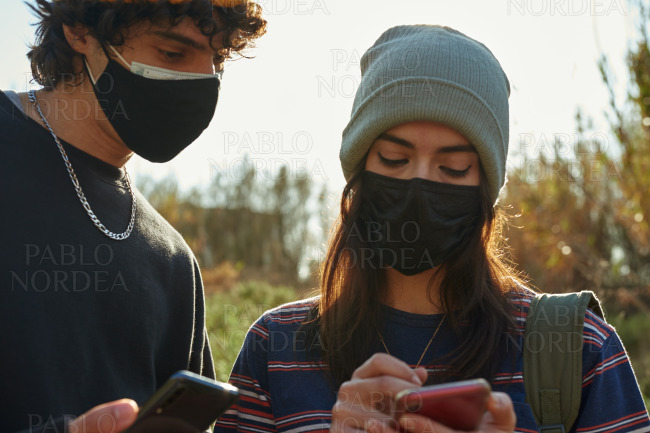 Young couple using their cellphones outdoors stock photo