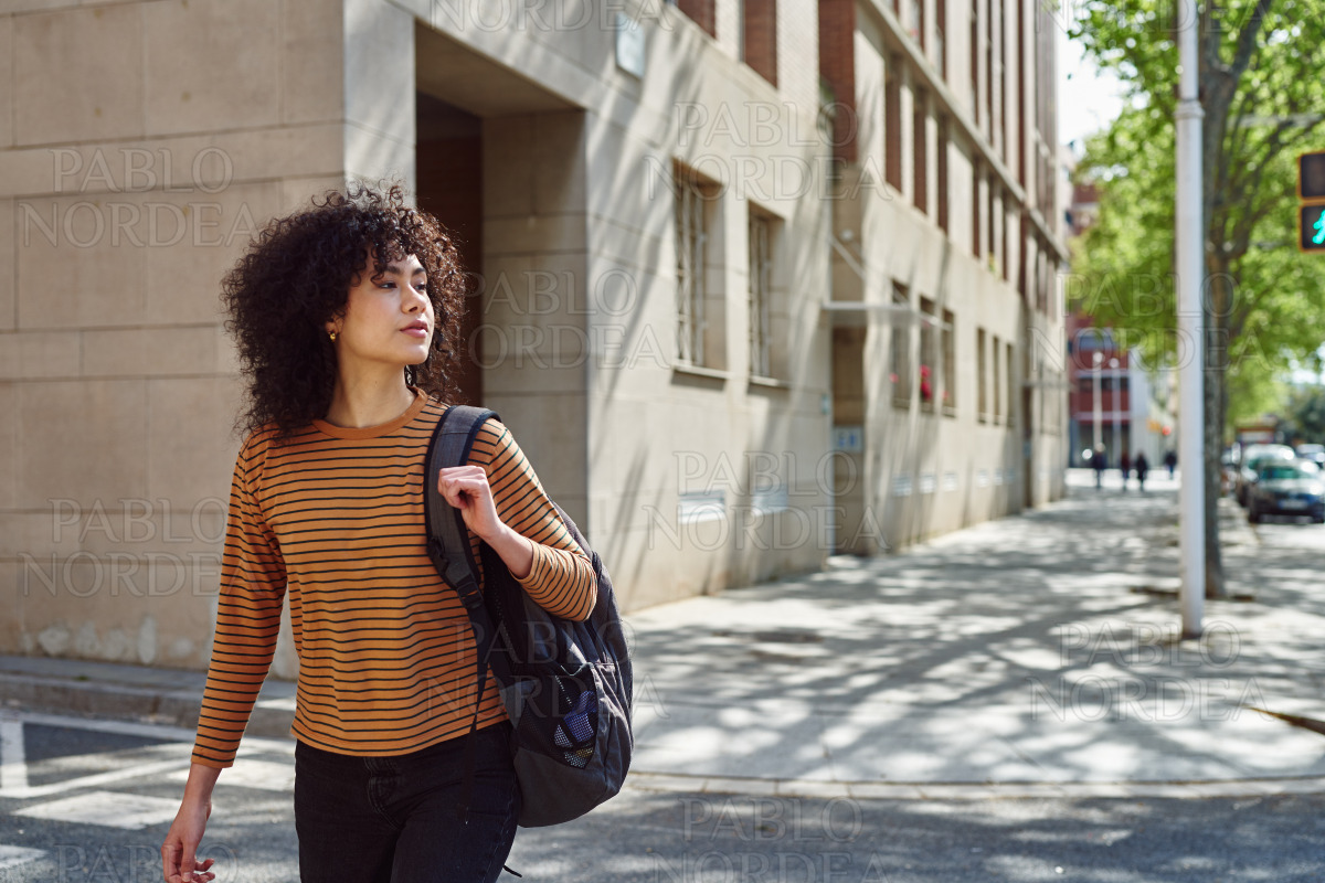 Cute black girl crossing a street outdoors stock photo