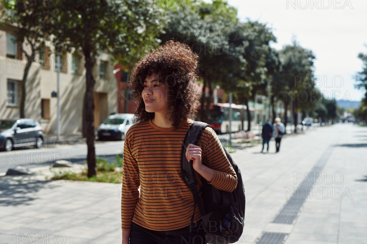Cute girl walking alone with a backpack stock photo