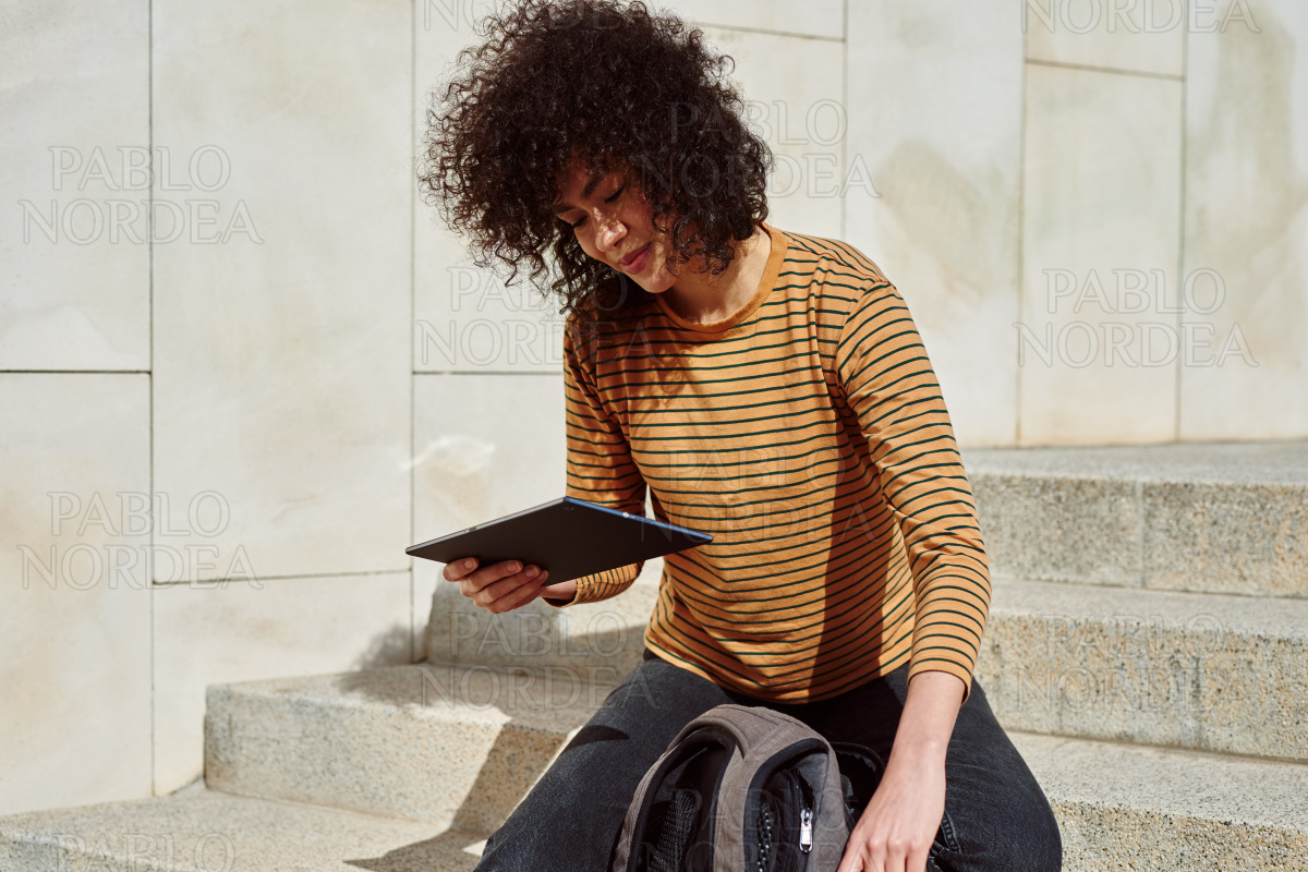 Girl reading from her digital tablet outdoors stock photo
