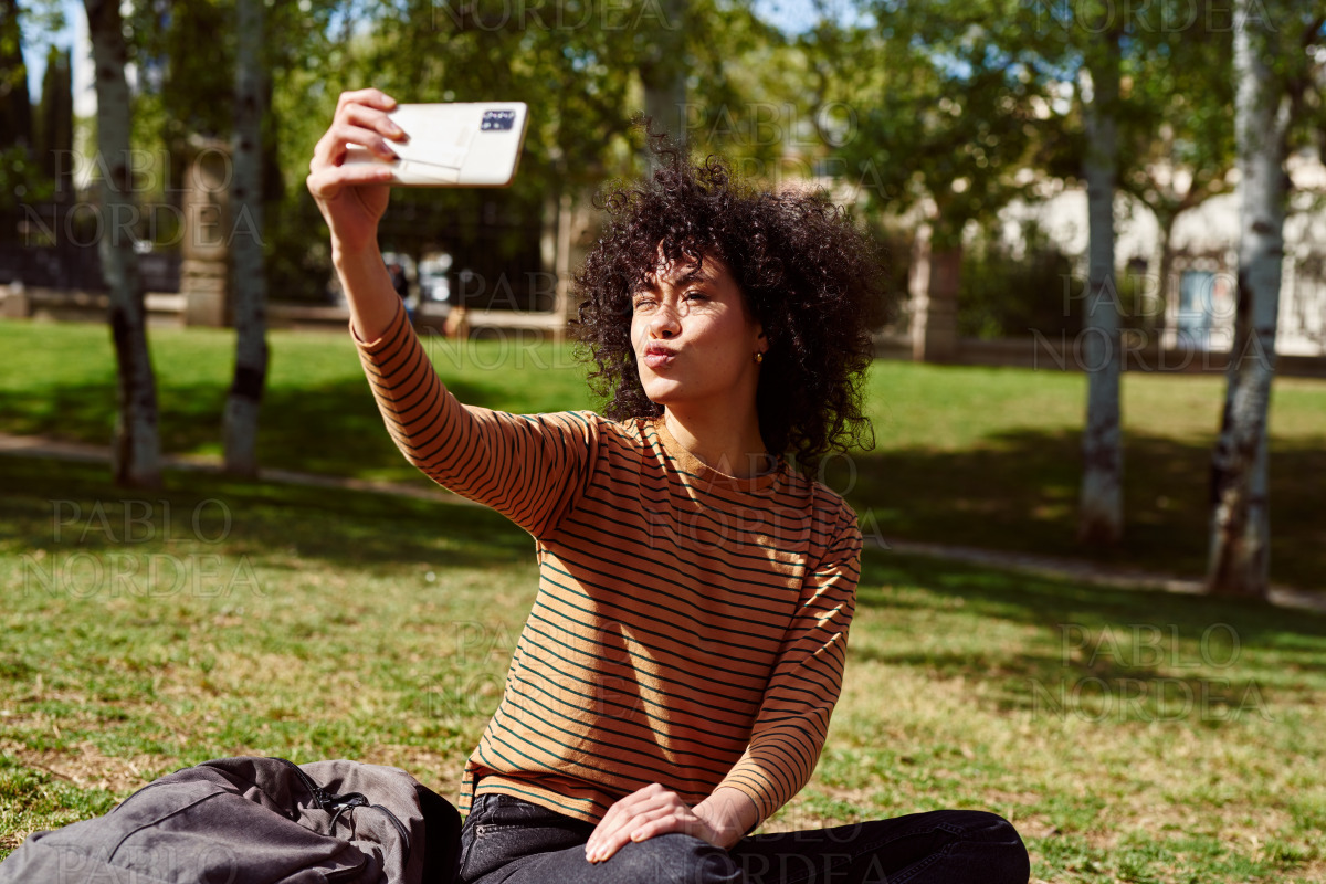 Pouting young woman taking a selfie in a park stock photo