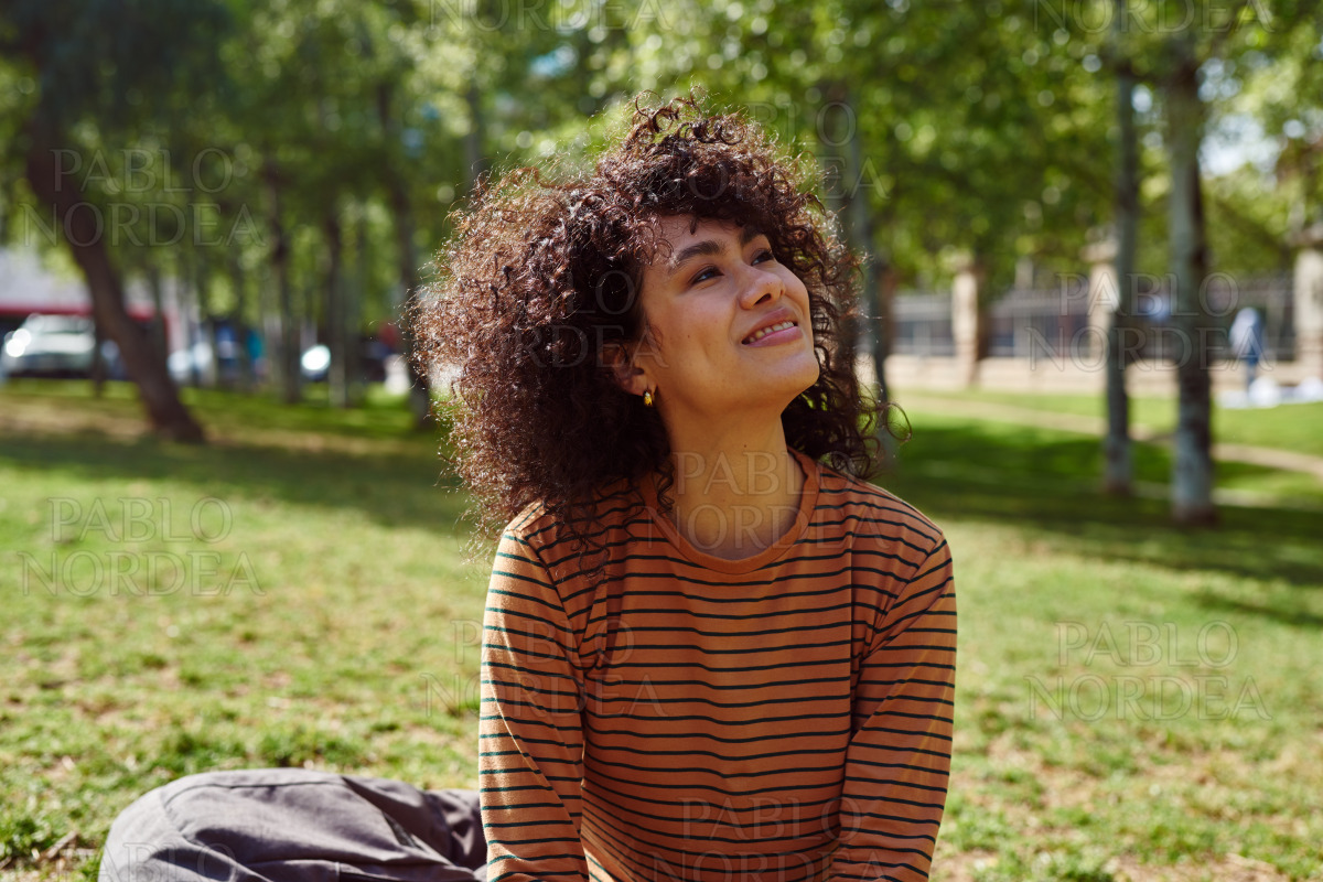 Smiling young woman looking away in a park stock photo