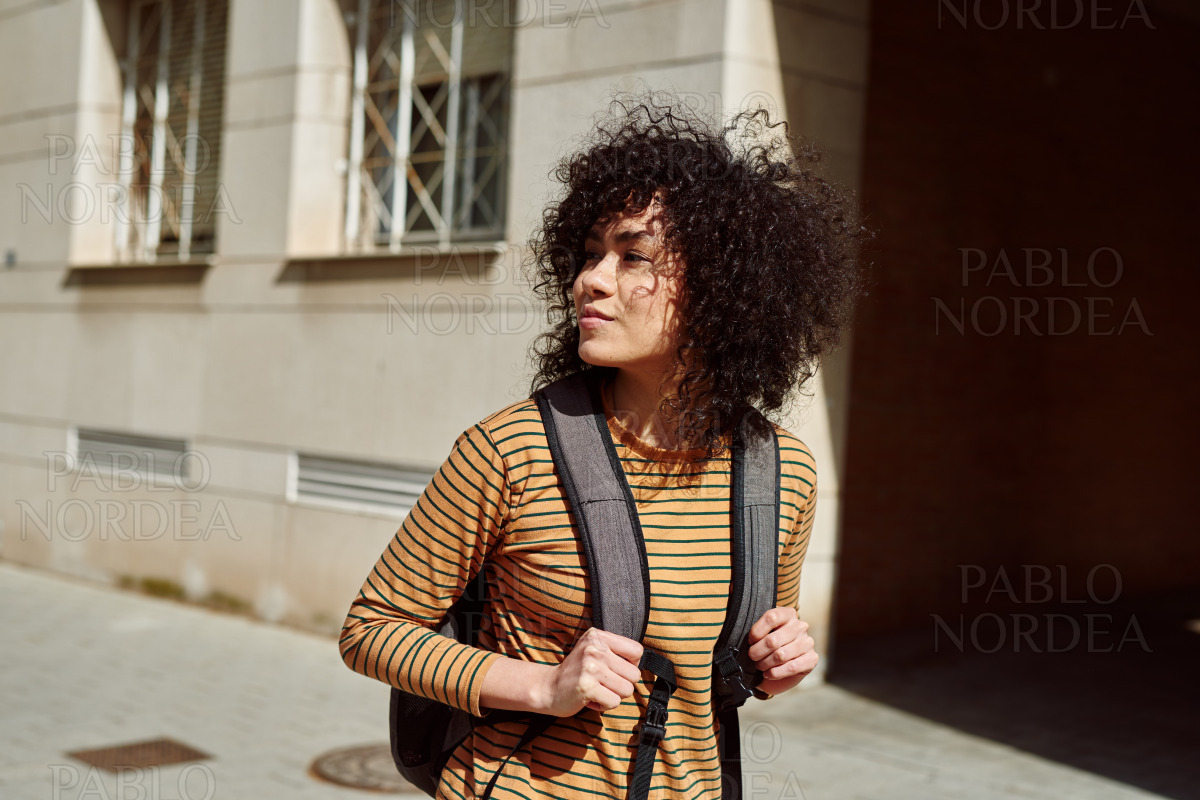 Young female student walking with a backpack stock photo