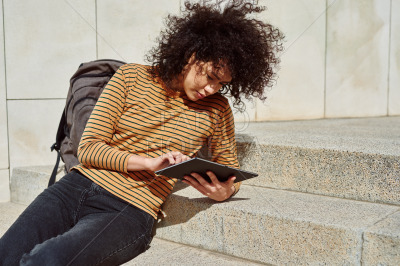 Attractive girl using a tablet pc outdoors