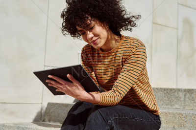 Cute girl using a digital tablet outdoors
