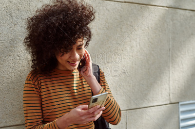Smiling girl using a cellphone outdoors