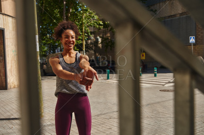 Smiling young woman doing stretch exercises