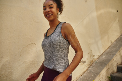 Smiling young woman jogging down the stairs