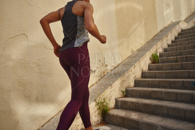 Unrecognizable sporty woman running on the stairs